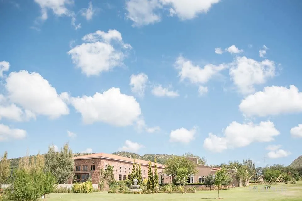 The estate buildings and gardens under a wide blue sky