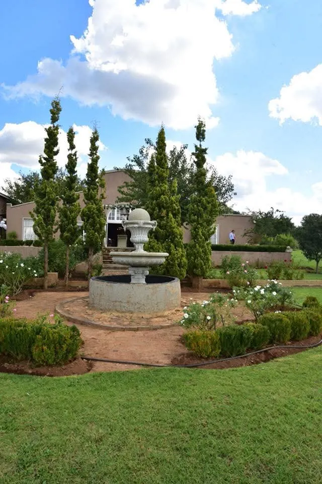 Garden fountain with rose beds and cypress trees